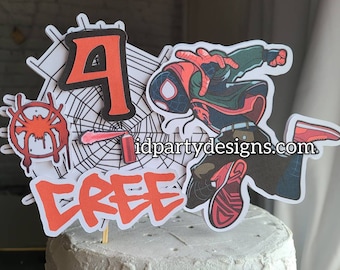 Puede incluir: Un topper de pastel de Spiderman rojo y negro con una lata de aerosol y un diseño de telaraña. El topper dice "CREE" y "4" en rojo. El sitio web idpartydesigns.com está impreso en el topper.