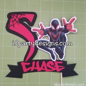 May include: A red and black cake topper featuring a cartoon image of Miles Morales, also known as Spider-Man, in a superhero pose. The topper includes a red number 5 with a black spider web design and a black banner with the name "CHASE" in red letters.