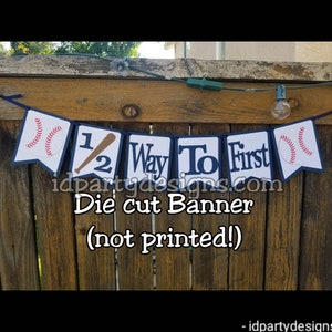 May include: A die-cut banner with a baseball theme. The banner reads "1/2 Way To First" with baseballs and a bat. The banner is navy blue and white with red accents.