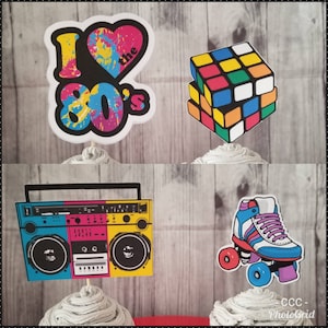 May include: Four cupcake toppers with 80s theme. Includes a Rubik's Cube, a boombox, a roller skate, and a topper that says "I love the 80's" with a heart. The toppers are colorful and set against a light wood grain background.