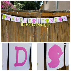 Puede incluir: Una pancarta blanca con letras rosas y verdes que dice "Waddle It Be?" con una silueta de pato rosa en cada extremo. La pancarta est&aacute; colgada en una valla de madera. El texto "ID Party Designs" est&aacute; impreso debajo de la pancarta.