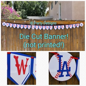 May include: A baseball-themed banner with the words "WELCOME LITTLE ALL STAR" in red and blue on white pennants. The banner is strung across a wooden fence. The banner also includes a baseball with the letters "LA".