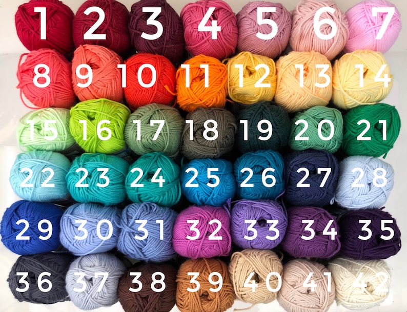 May include: A collection of 42 yarn balls in various colors, numbered 1 through 42. The colors include shades of red, pink, orange, yellow, green, blue, purple, brown, and cream. Each ball is tightly wound, suggesting they are for knitting or crochet projects.