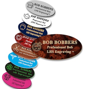 May include: A collection of oval-shaped name tags with different colored backgrounds and designs. The name tags all have the same text: "BOB BOBBERS Professional Bob LHS Engraving™".