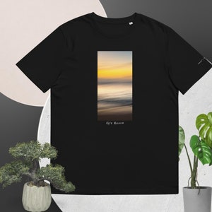 Może przedstawiać: Czarny T-shirt z grafiką rozmytego zachodu słońca nad oceanem. Tekst "Ke's Beach" jest nadrukowany pod obrazkiem.