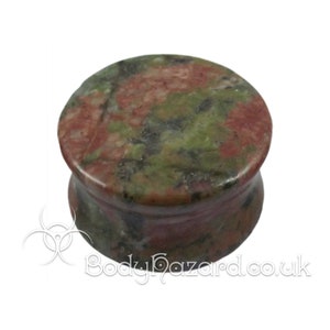 May include: A pair of green, pink, and black stone ear gauges. The gauges are made of a natural stone with a marbled pattern.