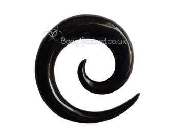 May include: Black spiral ear gauge made of acrylic. The gauge is a single piece of acrylic that is shaped into a spiral.