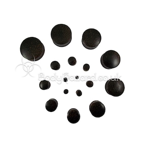 May include: A set of 14 wooden ear gauges in various sizes, ranging from small to large. The gauges are a dark brown colour and have a smooth, polished finish.