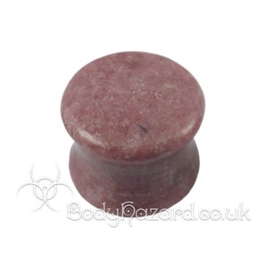May include: A pair of pink and white stone ear gauges. The gauges are made from natural stone and have a smooth, polished finish.
