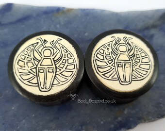 Um par de plugs de madeira de ébano preto de 33,5 mm com dupla flange e incrustação em padrão de escaravelho.