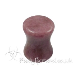 May include: A pair of purple stone ear gauges. The gauges are flared and have a smooth, polished finish.