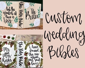 May include: Two white painted Bibles with floral designs and custom text. The first Bible has the text "...but the greatest of these is love" and "The Holy Bible". The second Bible has the text "The Prices". The second image shows two white painted Bibles with floral designs and custom text. The first Bible has the text "Mr and Mrs Ricks 12-17-21". The second Bible has the text "The Holy Bible" and "I have found the one whom my soul loves".