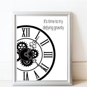 Könnte beinhalten: Schwarz-weißes Zifferblatt mit römischen Ziffern und Zahnrädern. Der Text "It's time to try defying gravity" ist über dem Zifferblatt gedruckt.