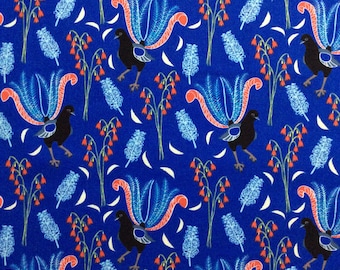 Könnte beinhalten: Blauer Stoff mit einem sich wiederholenden Muster aus stilisierten Vögeln mit orangefarbenem und blauem Gefieder, roten Blumen und weißen Blättern. Ein weißes Maßband mit schwarzen Markierungen befindet sich am unteren Rand des Bildes.