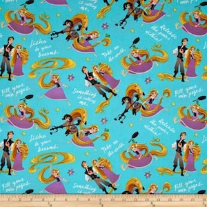 May include: A turquoise fabric with a repeating pattern of Rapunzel and Flynn Rider from the Disney movie Tangled. The pattern includes text from the movie, such as "Release the power within!" and "Take on the world."