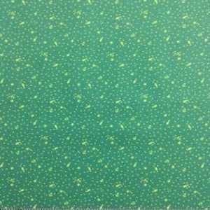 May include: Green fabric featuring a pattern of small white dots and yellow shapes. A wooden ruler with inch measurements is at the bottom of the image, with numbers from 12 to 22.