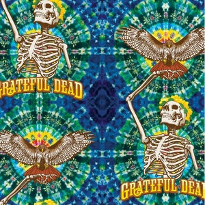 Pode incluir: Um padrão tie-dye com um esqueleto segurando um falcão em cada canto. O texto "GRATEFUL DEAD" está impresso em letras amarelas na parte inferior da imagem.