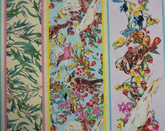 May include: A colorful fabric with a repeating pattern of birds, flowers, and leaves. The fabric is striped with light blue, pink, and yellow stripes. The fabric is measured with a ruler in inches.