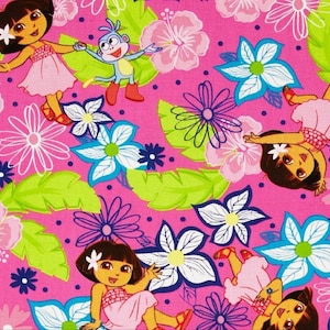 May include: Pink fabric with a repeating pattern of cartoon characters, flowers, and leaves. The characters are Dora the Explorer and Boots the Monkey. The flowers are pink, blue, and white. The leaves are green.