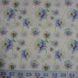 May include: A white fabric with a repeating pattern of blue and purple watercolor flowers. The fabric has a ruler at the bottom with numbers 26 through 34.