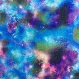 Può includere: Tessuto dai colori vivaci con un motivo galattico nelle tonalità del blu, viola, rosa e verde. Il tessuto ha un aspetto maculato, con un righello in basso che mostra misure da 33 a 51 cm.