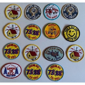May include: A collection of embroidered patches with various designs and text. Some patches feature a house with a radio antenna, while others display phrases like "From Me 73's 88's To You" and "World's Greatest Skip-Talker."