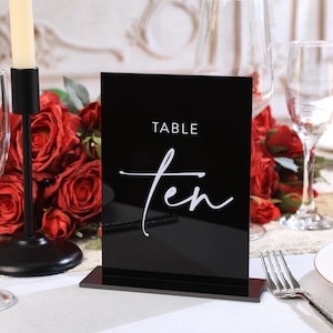 May include: Black acrylic table number with white text that reads "TABLE ten".