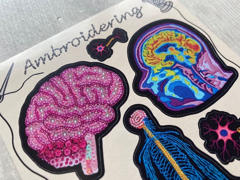 Puede incluir: Parches bordados con diferentes ilustraciones anat&oacute;micas del cerebro, una neurona y un nervio. Los parches est&aacute;n sobre un fondo beige con la palabra "Embroidering" escrita en negro.
