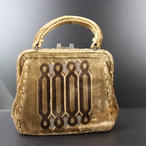May include: A vintage brown velvet handbag with a geometric design. The handbag has a top handle and a clasp closure.