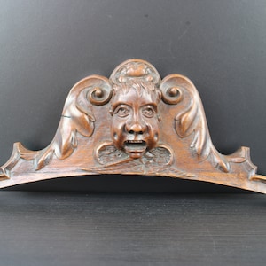 Antique carved wooden ornement with mans head.