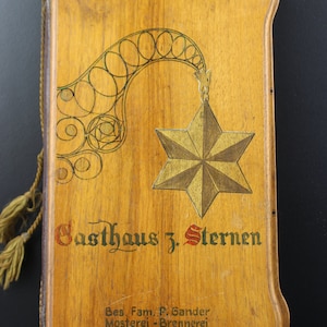 Antique wooden book holder with commercials on the inside and outside.