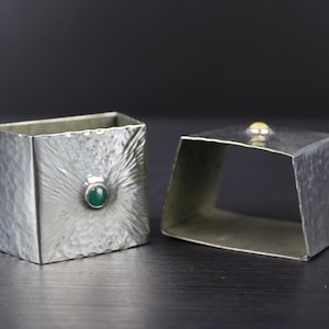 Art & Crafts pair of hammered silver plated napkin rings with inlaid stones.