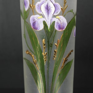 Pu&ograve; includere: Vaso in vetro smerigliato con un design di iris dipinto a mano. L'iris presenta petali viola, foglie verdi e dettagli dorati. Il vaso &egrave; cilindrico e ha una finitura liscia e smerigliata, creando un aspetto elegante.