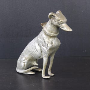 Antique metal dog sitting with an inkwell.