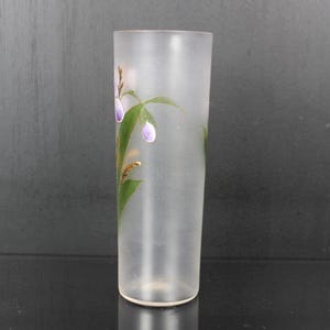 Pu&ograve; includere: Un vaso di vetro smerigliato di forma cilindrica. Il vaso &egrave; decorato con fiori viola dipinti a mano, foglie verdi e dettagli dorati. Il vaso &egrave; alto circa 20 cm.