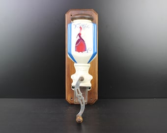 Art Deco earthenware lady on front wall mounted coffee grinder.