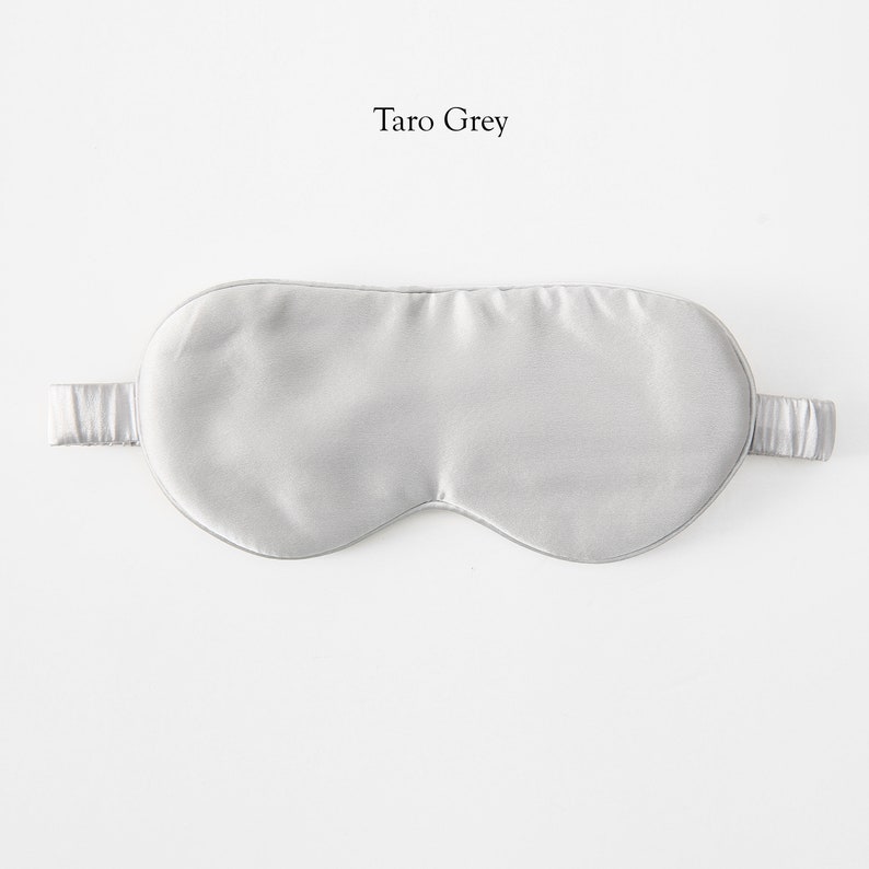 May include: A gray silk sleep mask with adjustable straps. The mask is labeled "Taro Grey".