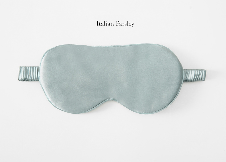 May include: A light blue sleep mask made of silk. The mask has an elastic band for a comfortable fit.