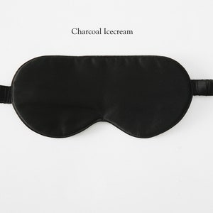 May include: A black silk sleep mask with an elastic strap. The mask is designed to block out light and help you sleep.