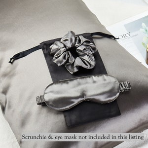 May include: A gray silk pillowcase with a black and gray silk eye mask and a gray silk scrunchie in a black pouch.  The text "Scrunchie & eye mask not included in this listing" is at the bottom of the image.