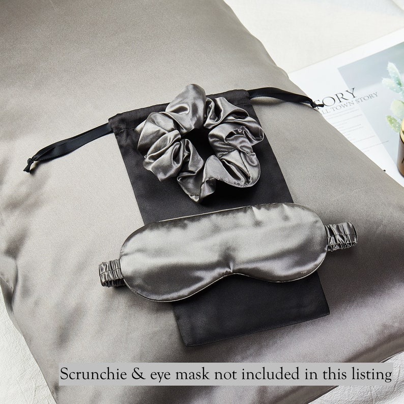 May include: A gray silk pillowcase with a black and gray silk eye mask and a gray silk scrunchie in a black pouch.  The text "Scrunchie & eye mask not included in this listing" is at the bottom of the image.