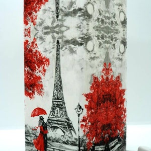 May include: A white rectangular lamp base with a black and white image of the Eiffel Tower, a couple holding a red umbrella, and red trees. The lamp base has a white background with a grey and black textured pattern.