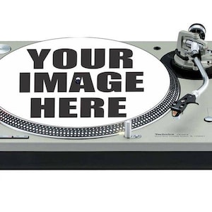 Puede incluir: Un tocadiscos Technics SL-1200 plateado con una alfombrilla blanca que dice "YOUR IMAGE HERE".