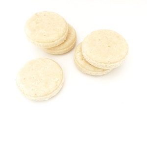 Könnte beinhalten: Fünf runde, weiße, zuckerfreie Atemminzen.