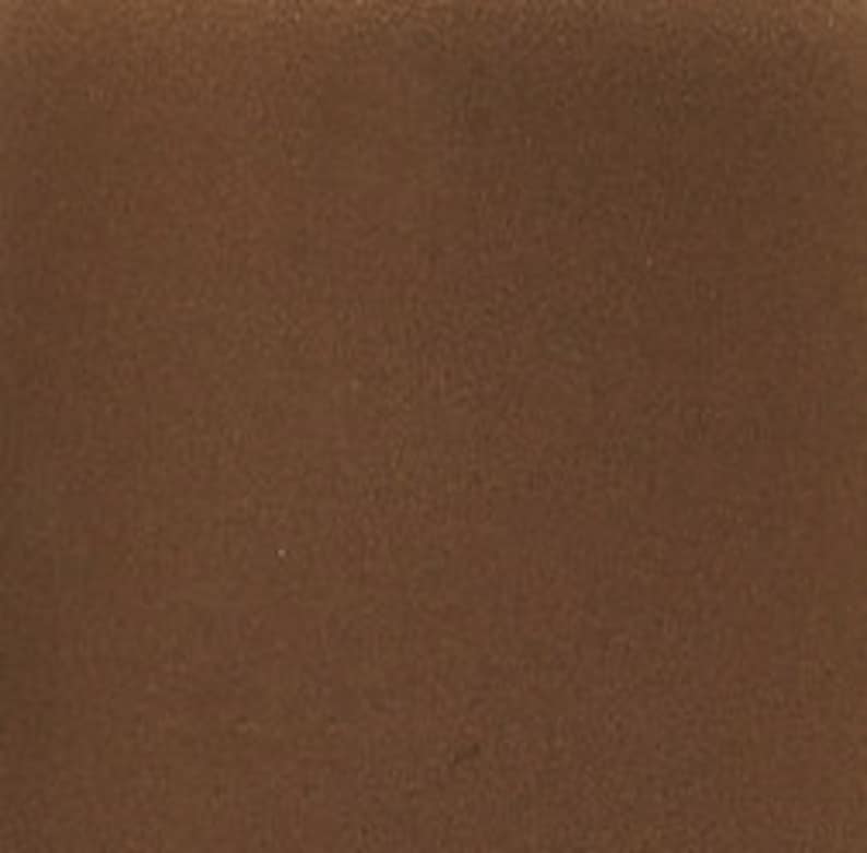 May include: A close-up of a brown leather surface. The leather has a smooth, even texture.