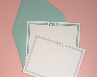May include: A white card with a light blue and green border. The card has the text "CRP" and "SKL" printed on it. The card is sitting on a light pink surface.