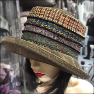 Puede incluir: Un sombrero de fieltro marr&oacute;n con ala ancha y una banda de patr&oacute;n multicolor. La banda est&aacute; hecha de diferentes tipos de tejido de tweed.