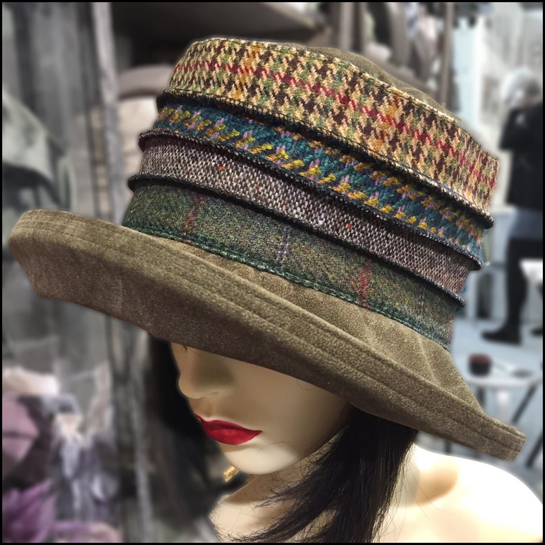 Puede incluir: Un sombrero de fieltro marr&oacute;n con ala ancha y una banda de patr&oacute;n multicolor. La banda est&aacute; hecha de diferentes tipos de tejido de tweed.
