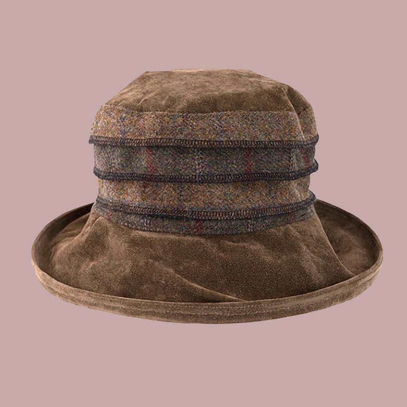 Puede incluir: Un sombrero de gamuza marr&oacute;n con una banda de tela a cuadros alrededor de la corona.