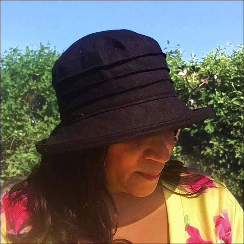 Puede incluir: Un sombrero de sol negro de ala ancha y corona plisada. El sombrero est&aacute; hecho de una tela suave y ligera, ideal para proteger la cara y el cuello del sol.